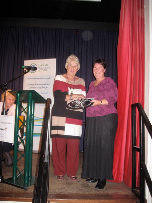 Hankelow Amenity Group Chairman Val Morrey receives the award,  which consists of a wall plaque, certificate and a cheque for £100, from Mrs Kathy Benn.